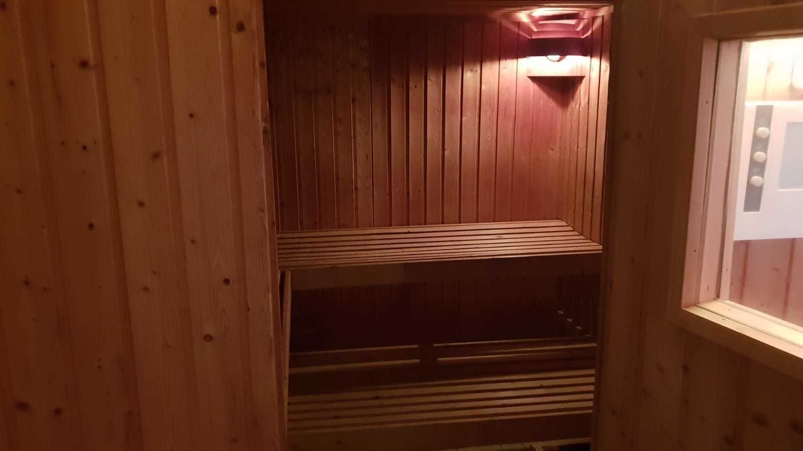 Ein Holzinnenraum mit schrägverdeckter Decke und einem Fenster zur Rechten.