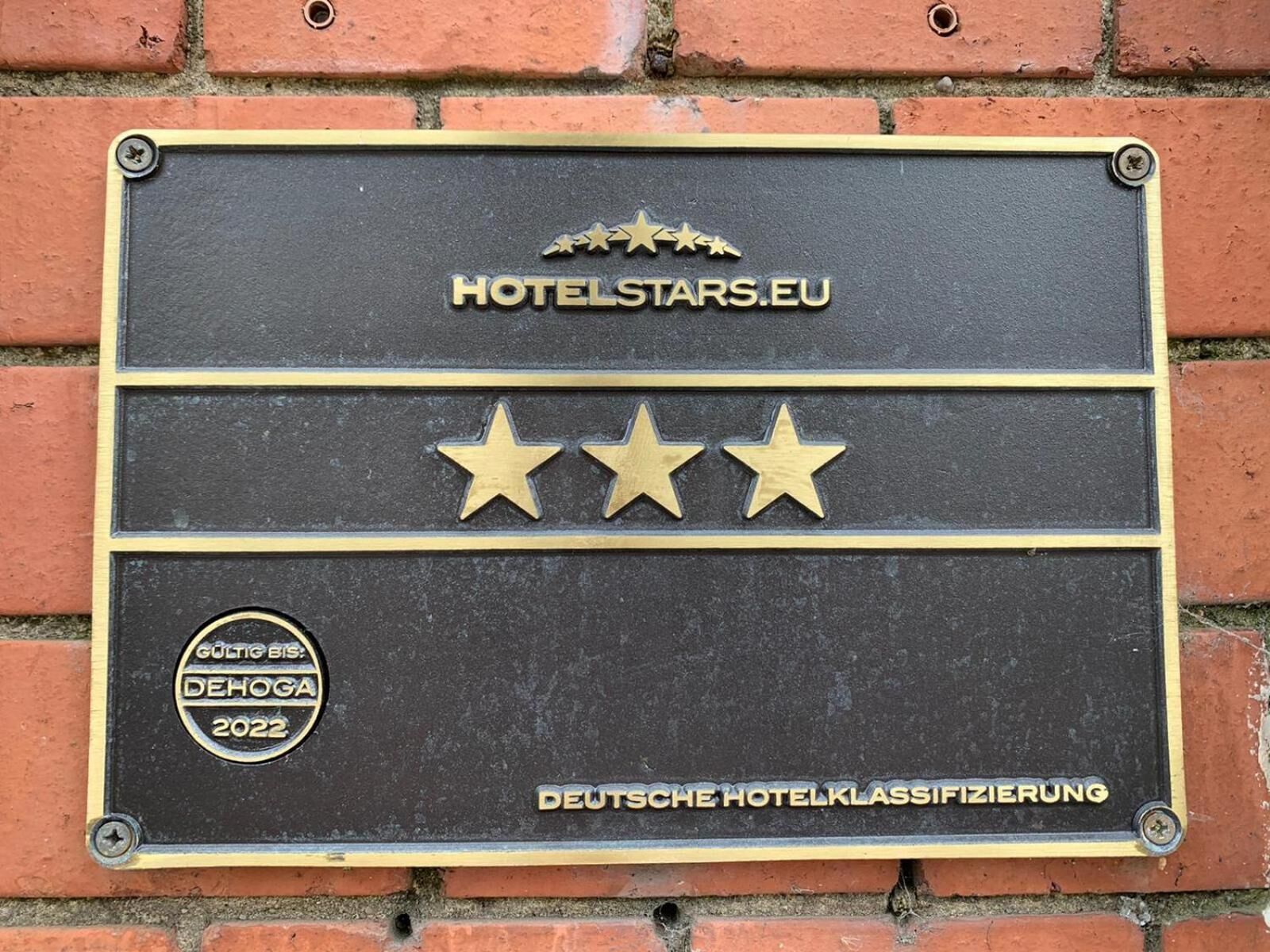 Une plaque portant l’inscription « HOTELSTARS.EU » et trois étoiles, indiquant la catégorie de l’hôtel.