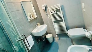 Un baño moderno con dos lavamanos, inodoro y zona de ducha.