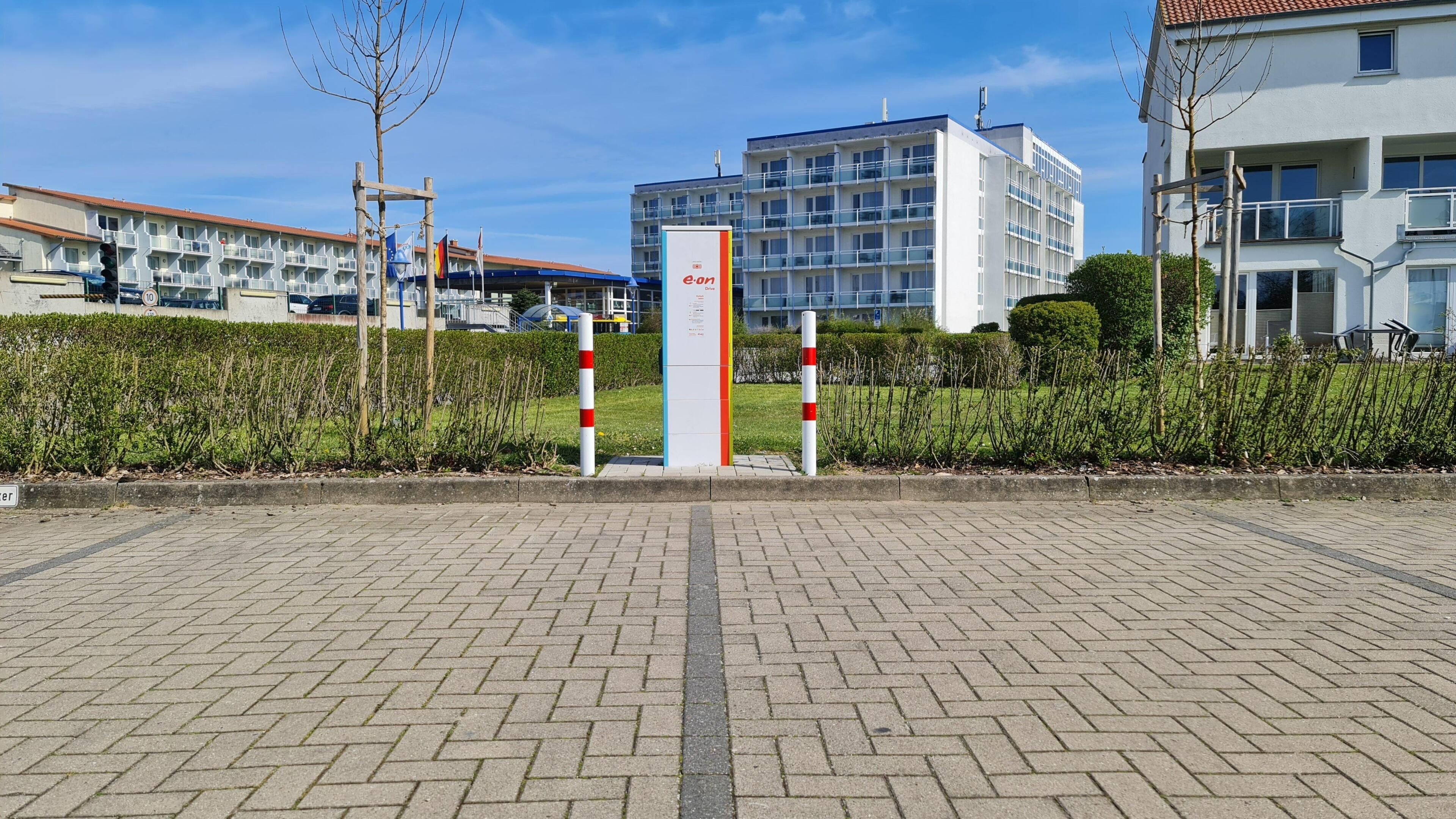 Ein gepflasterter Weg führt zu einem Gebäude, an dem das Schild 'e-on' zu sehen ist.