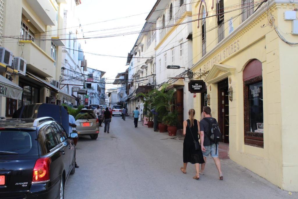 Una calle estrecha bordeada de edificios, algunos con letreros que indican tiendas o negocios.