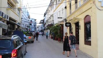 Una calle estrecha bordeada de edificios, algunos con letreros que indican tiendas o negocios.