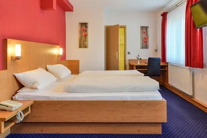 A hotel room with a large bed, bedside tables, a desk, and a chair. - Hotel Gasthof Rotes Rovu (Heroldsberg)