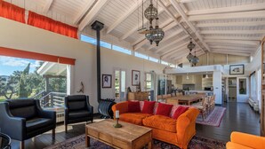 A spacious living area with a high ceiling, a large sofa, a coffee table, and a view of the outdoors. - The Lodge Ronda (Ronda)