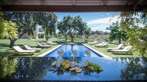 A poolside area with lounge chairs and a table with lemons and glasses. - The Lodge Ronda (Ronda)