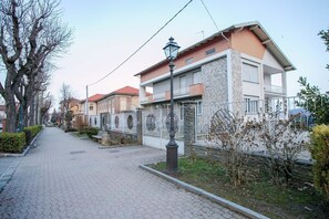 A residential street with modern houses, a paved walkway, and a street lamp. - Boulevard 900 - Comfort and Style - Entire Structure 12 Beds (Revello)