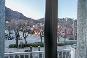 A view from a window overlooking a street with buildings, trees, and a hilly landscape. - Boulevard 900 - Comfort and Style - Entire Structure 12 Beds (Revello)