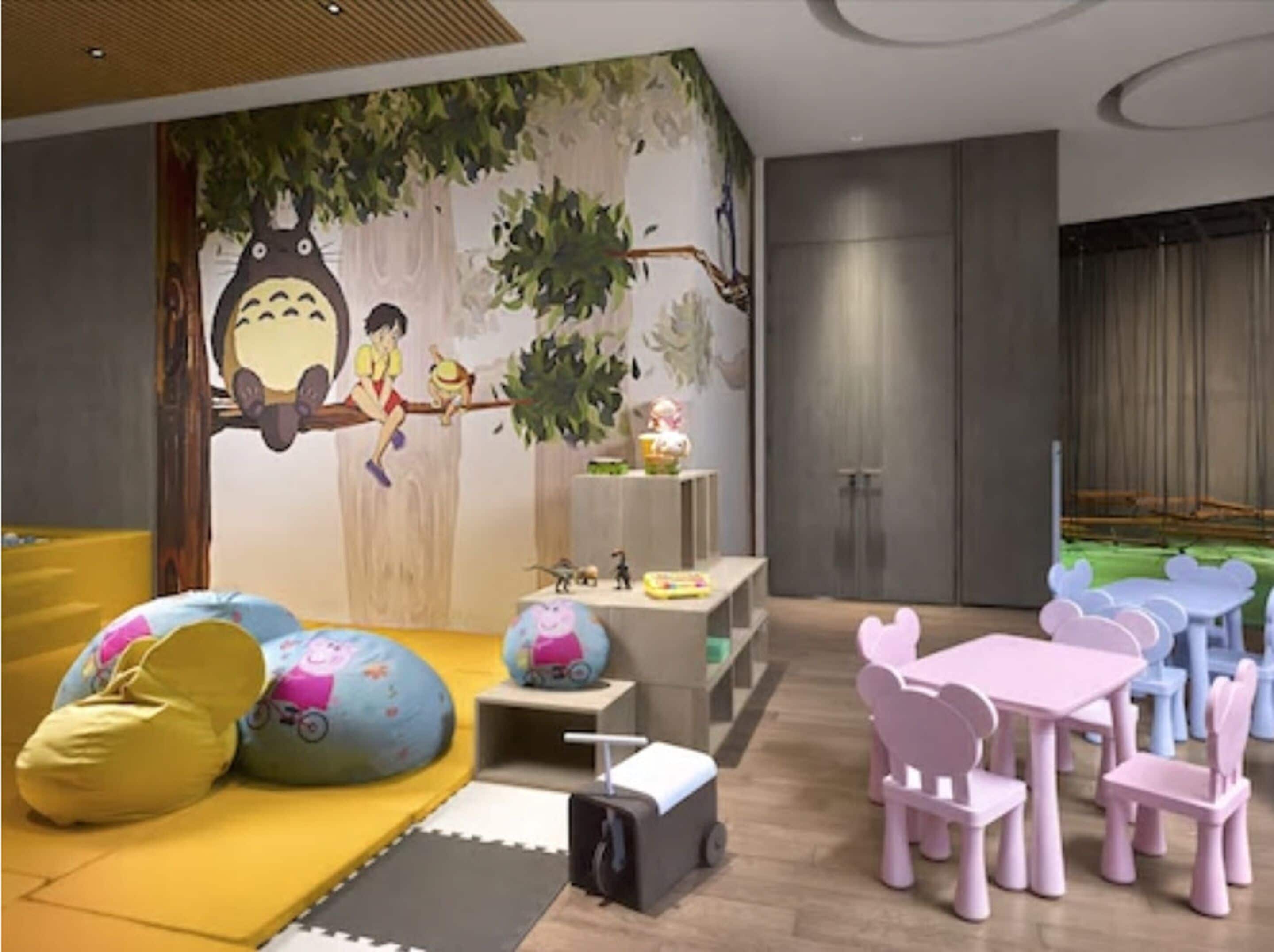 A children's play area with colorful furniture and a mural on the wall.