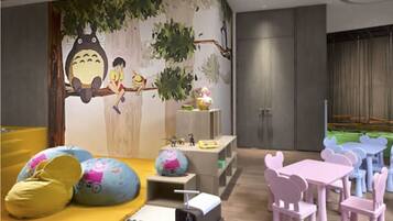 A children's play area with colorful furniture and a mural on the wall.