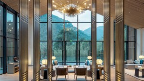 Un interior espacioso con grandes ventanales que ofrecen vistas a la montaña, muebles modernos y un diseño de techo único.