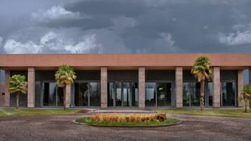 A modern building with a flat roof, large glass windows, and a symmetrical facade.