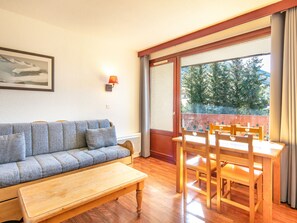 Una habitación con sofá, mesa de madera y sillas.