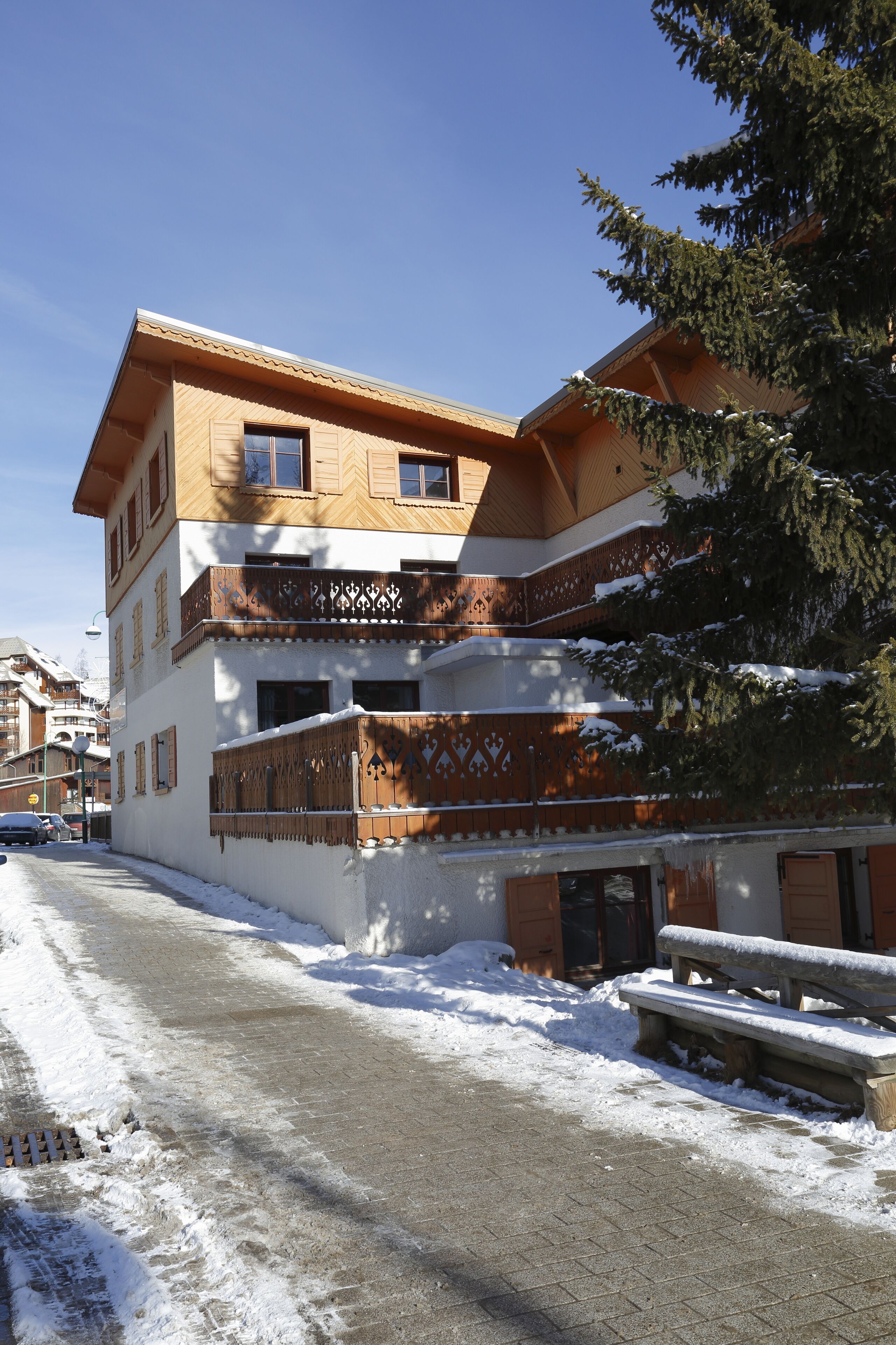 A multi-story building with a snow-covered ground and a clear sky.