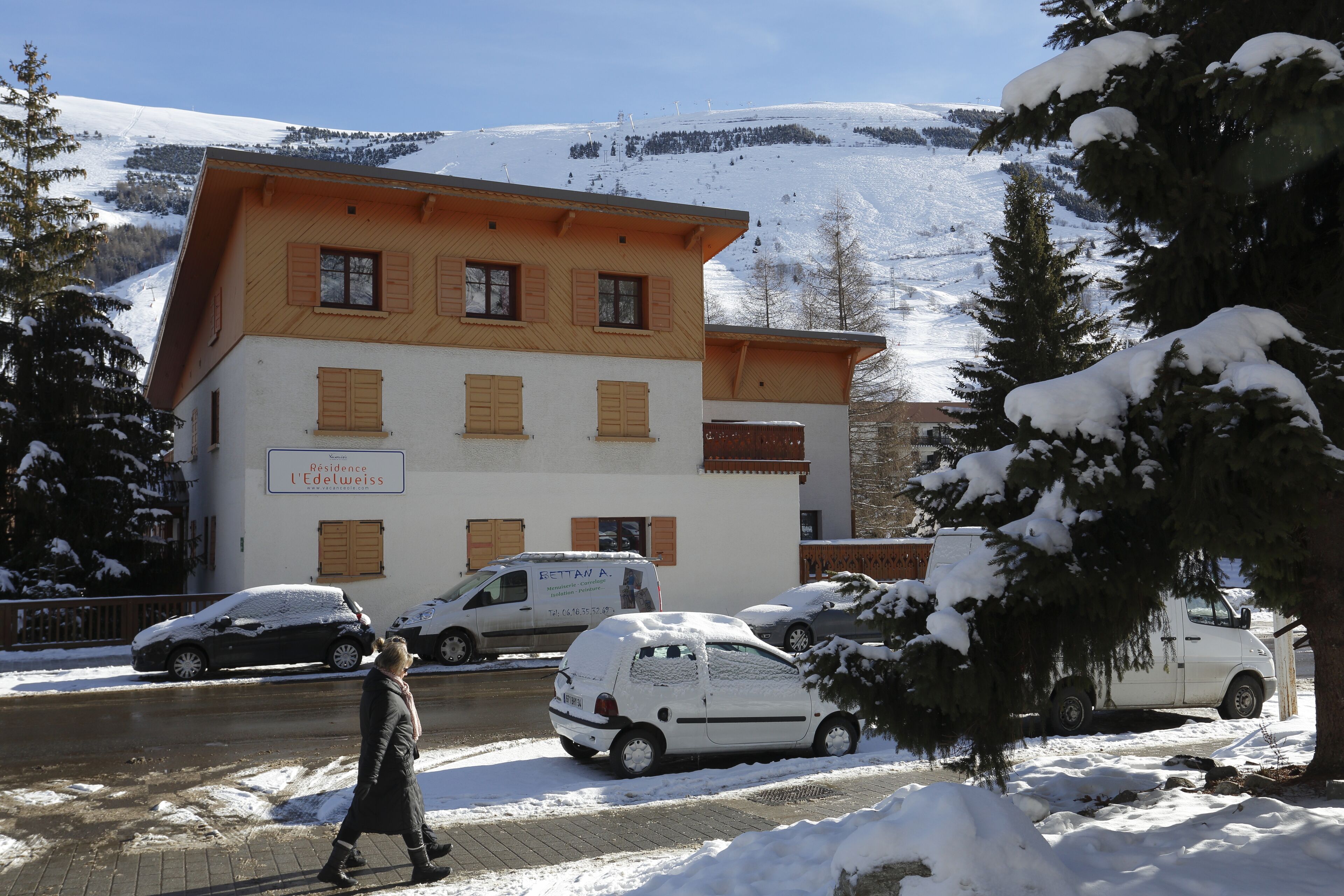 A building with a sign reading "Residence l'Edelweiss" and a parked van in front.