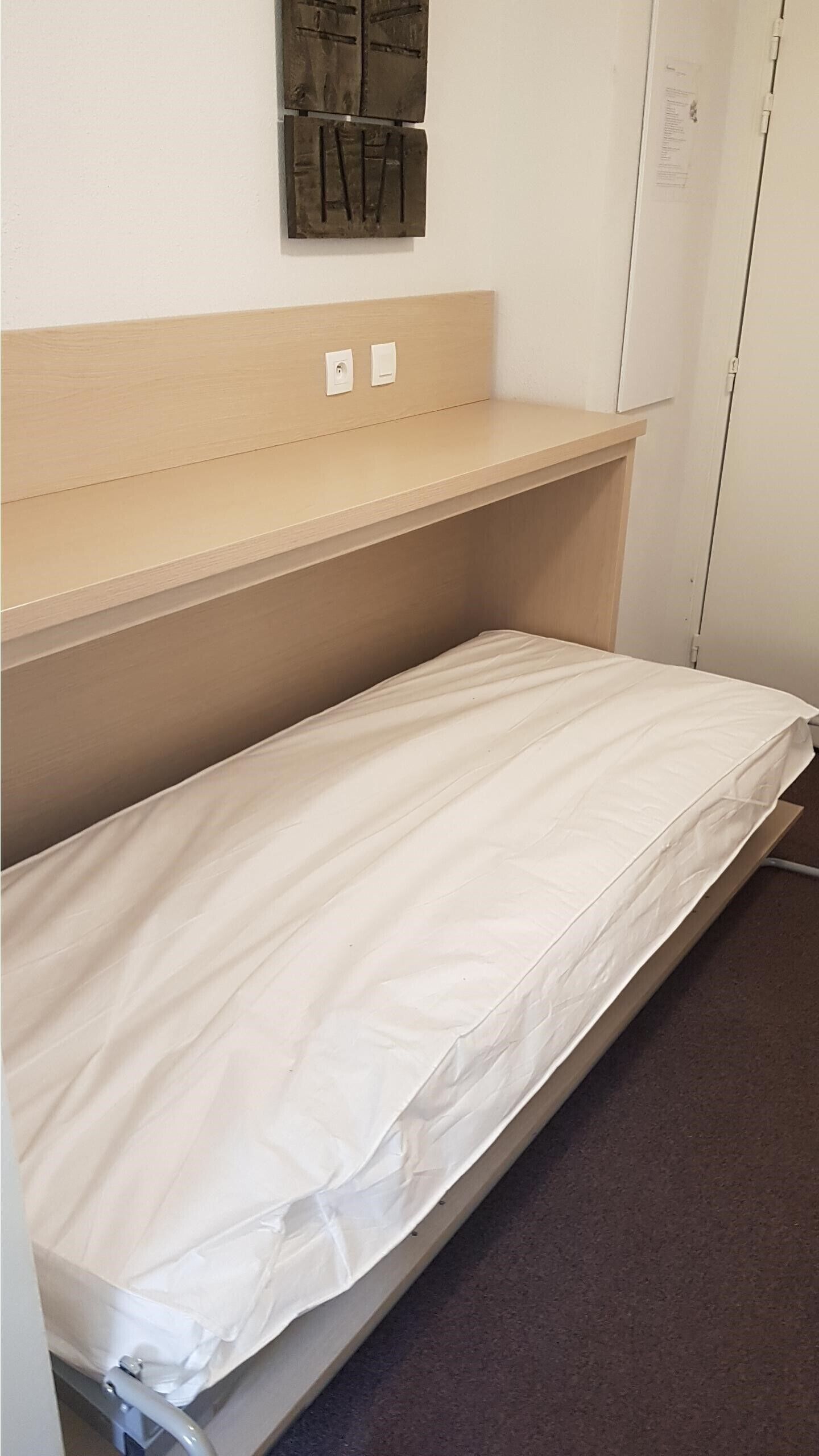 A bunk bed with a mattress and a headboard.