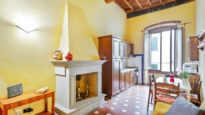 Una sala de estar con chimenea, muebles de madera y un comedor con mesa y sillas.