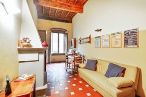 A cozy living area with a sofa, a dining table, and a kitchen area.