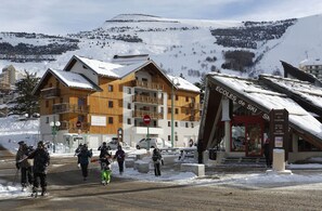 A ski resort with wooden buildings, a ski office, and a sign for ski schools.