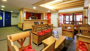 Un restaurante acogedor con mobiliario de madera y una barra.