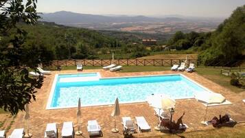Una piscina al aire libre de temporada, sombrillas, tumbonas
