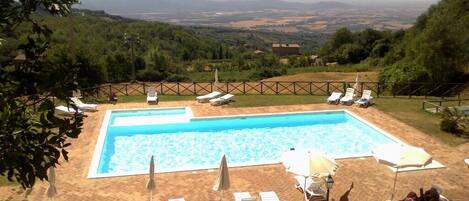 Piscina a l'aire lliure de temporada, para-sols i gandules