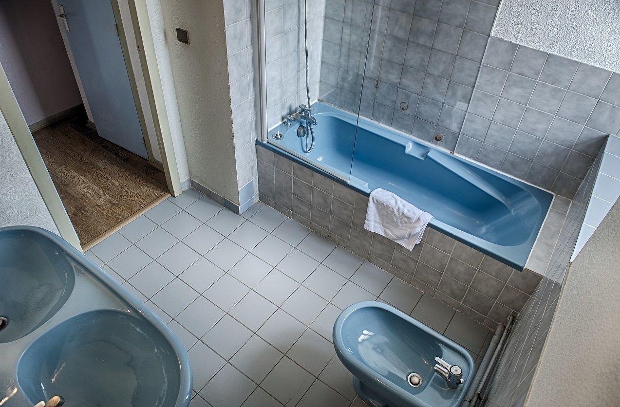 Un baño con bañera, dos lavabos y suelo de baldosas.