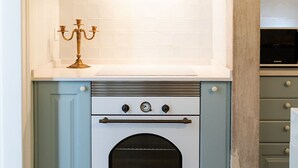 Una cocina con estufa blanca, candelabro y microondas.