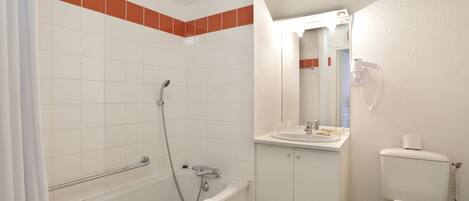 A bathroom with a bathtub, toilet, and sink.