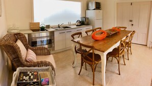 Una cocina compacta con una mesa de comedor, sillas y un sofá de mimbre.