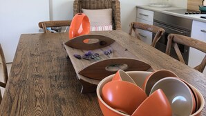 Una mesa de comedor de madera con un reloj en la pared de arriba.