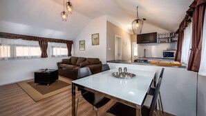 Eine moderne Küche mit Essbereich, einer Couch und einem Fernseher.