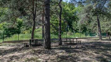 Un parque con mesas de picnic y un área cercada.