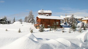 A snow-covered landscape with wooden cabins and a ski resort. - Vacancéole - Résidence Les Gorges Rouges (Guillaumes)