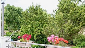 A garden with potted plants and a metal railing. - Pergusa Lake Home (Enna)