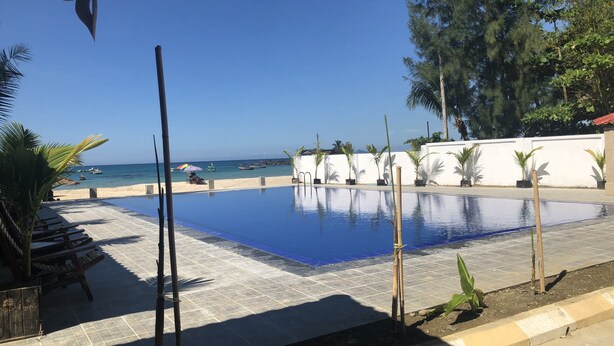 Una piscina con vistas a la playa y al océano.