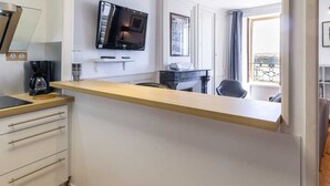 A modern kitchen with a built-in microwave, a coffee maker, and a small dining table.