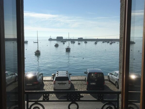 A view of a marina with several boats and cars parked along the dock.