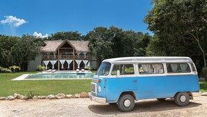 A blue and white van parked in front of a house with a pool and a thatched roof. - Seclusive & Relaxing villa in the jungle of Xpu-Ha by Happy Address (Kantenah)