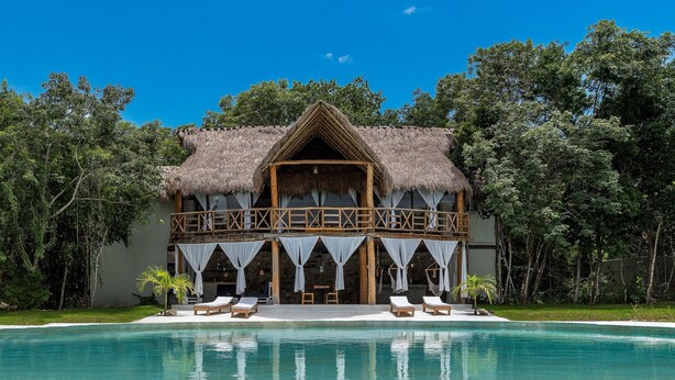 A thatched-roof building with a pool in front, surrounded by trees. - Seclusive & Relaxing villa in the jungle of Xpu-Ha by Happy Address (Kantenah)