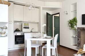 Deluxe appartement | Privékeuken | Een koelkast, een oven, kookgerei, borden en bestek