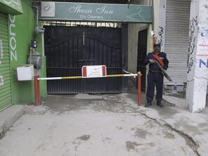 A gated entrance to a building with a sign reading "Shexa Inn Dry Cleaners."