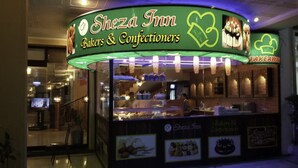 A bakery named Sheza Inn with a sign indicating it offers bakers and confectioners services. - Sheza Inn Hotel Multan (Multan)