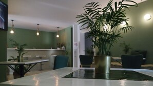 Un comedor con una mesa, sillas y una planta en maceta.