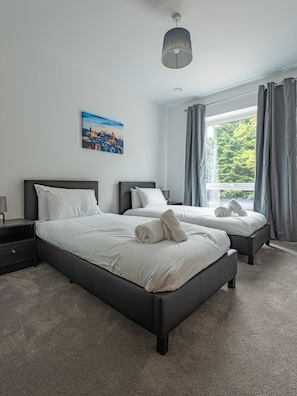 Relax in a stylish room with a large bed, bedside table, and cityscape artwork.