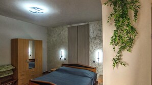 Une chambre à coucher avec un lit, une armoire et une plante fixée au mur.
