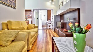 A modern living room with a sofa, a coffee table, and a green vase with flowers. - A one bedroom semibasement apartment - Lana 2 (Petrovija)