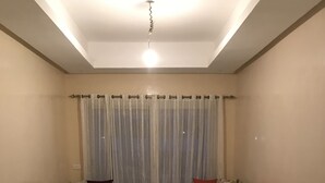 Un salon avec deux canapés sombres, une table basse au centre et un luminaire au plafond.