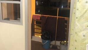 Une pièce avec une fenêtre, une porte, une petite fenêtre, une poubelle et un panier à carreaux.
