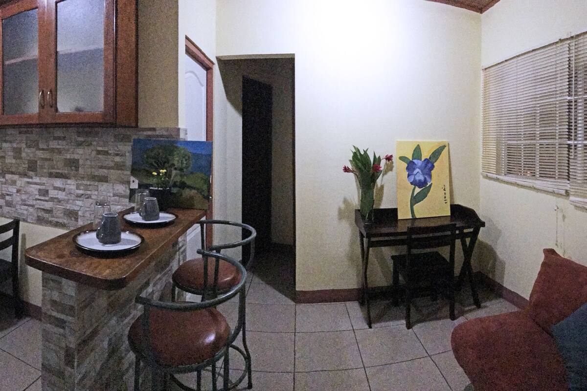 A compact living space with a kitchen, dining area, and a seating area with a couch.