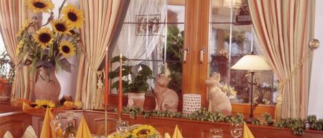 A dining table set with yellow napkins, sunflowers, and a vase of flowers.